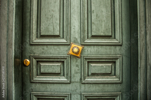Antique green door with golden handle close-up
