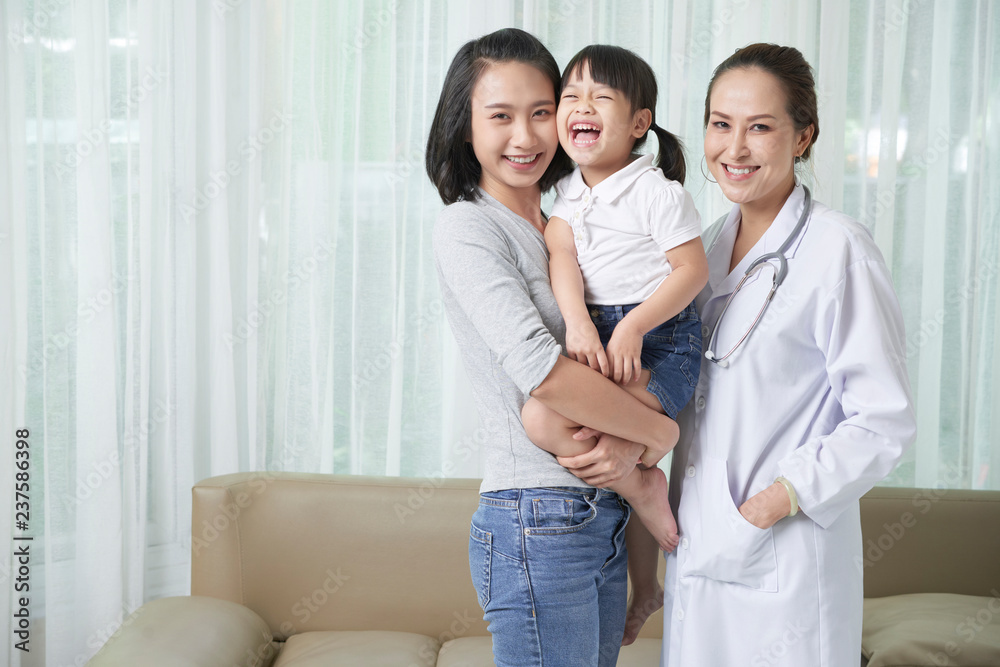Joyful little Vietnamese girl, her mother and pediatrician Joyful little Vietnamese girl, her mother and pediatrician