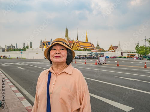 Portrait of Senior Tourist in Wat Phrakeaw Temple  with Cloud sky.Wat Phrakeaw Temple is the main Temple of bangkok Capital of Thailand © Sumeth