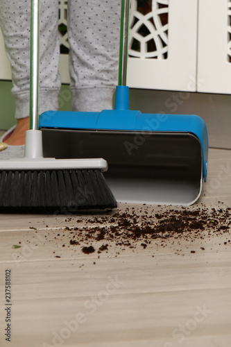 brush and dustpan cleaning floor