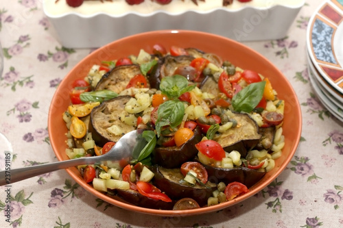 Salad with roasted aubergine and vegetables, served on a table. Selective focus.