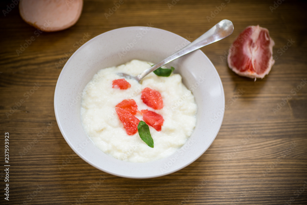 sweet boiled semolina porridge in a plate with slices of red grapefruit sweet boiled semolina porridge in a plate with slices of red grapefruit