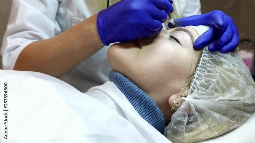 The procedure of permanent eyebrow makeup in a beauty salon. The procedure of permanent eyebrow makeup in a beauty salon.