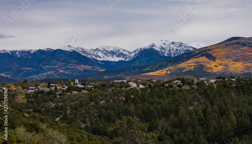Small town at the foot of mountains with snow cap tops and autumn forest © James Sakaguchi