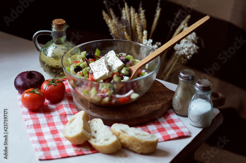 Greek salad with fresh vegetables: tomato, onion, pepper, olives, cheese, ogreuts, basil and spices. The recipe for tasty and healthy food. Dietary lunch of farm products. 