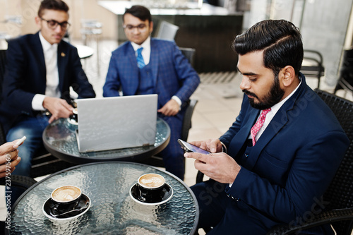 Photography Group of indian business man in suits sitting at office on cafe with laptop, texting on phones and making photo of coffee