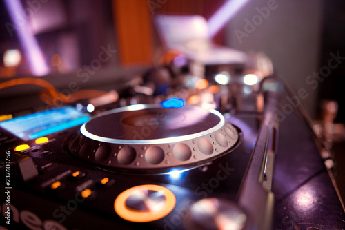 Dj mixes the track in the nightclub at party. In the background laser light show