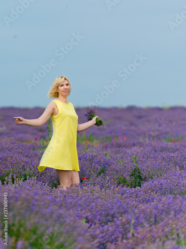 Fototapeta Naklejka Na Ścianę i Meble -  Young girl in yellow dress, posing in a lavender field.