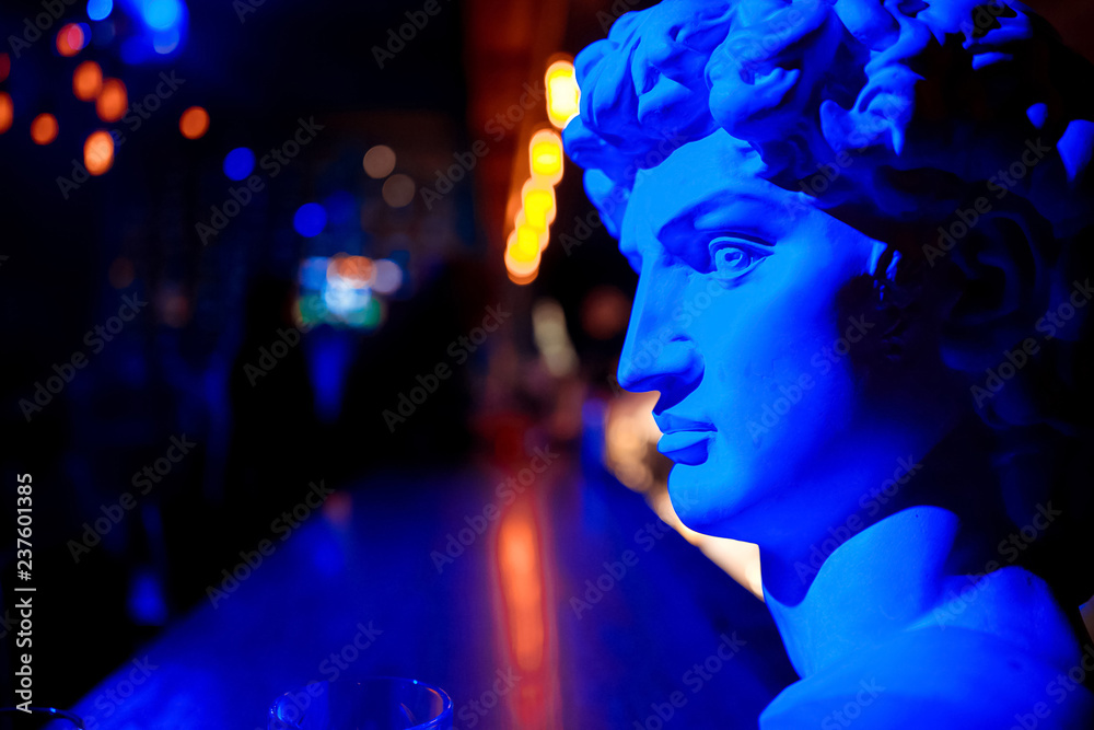 a statue of a man in red and blue light a statue of a man in red and blue light