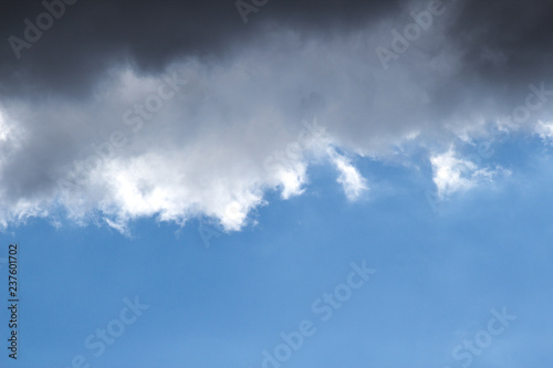 a thundercloud blocking the sun against the blue sky