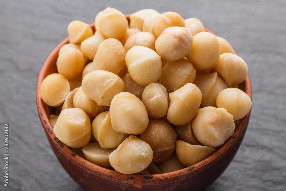 delicious macadamia nuts on a dark stone background delicious macadamia nuts on a dark stone background