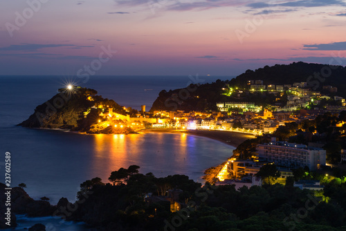 Illuminated City of Tossa de mar, Spain, and reflections of the ocean in blue hour after sunset