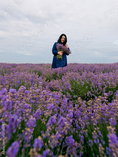 Young girl in blue dress, posing in a lavender field.