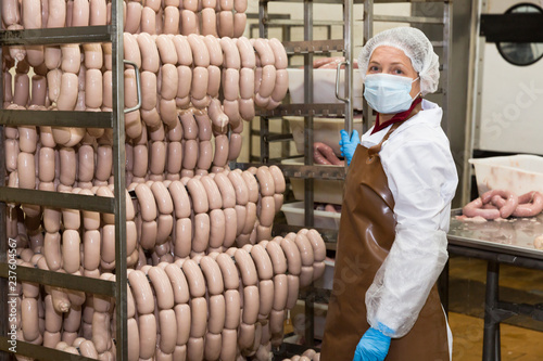 Female carrying sausages on racks