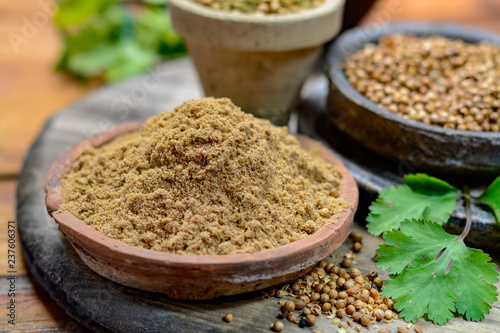 Clay bowls wirh dried coriander seeds and coriander powder close up, spices collection