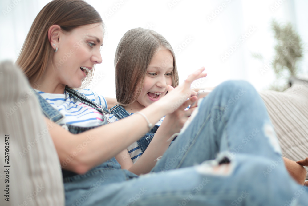 close up.happy mom and her daughter are watching videos on smartphone