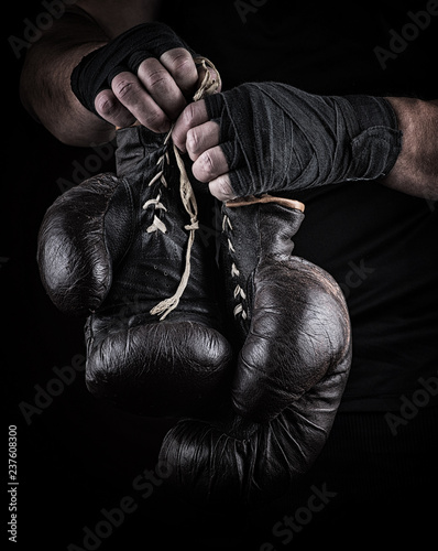 very old boxing sports gloves in men's hands © nndanko