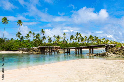 Broken bridge under palm trees between islets over lagoon, North Tarawa atoll, Kiribati, Micronesia, Gilbert islands, Oceania, South Pacific Ocean.