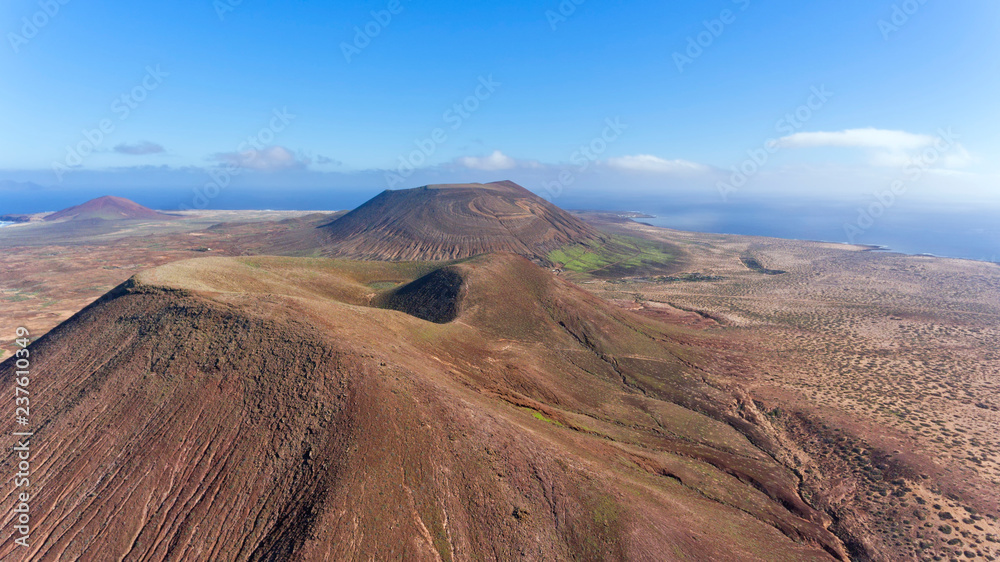 Fototapeta premium Panorama over volcanic mountains in Lanzarote, Canary Islands, Spain, aerial view .