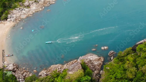 Aerial drone top view of white sand tropical exotic paradise tiny shore in Koh Prangan island, Thailand. Small boats on ocean surface. Cute remote beach with volcanic stones and green coconut palms. photo