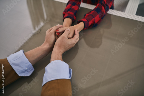 Top view photo of couple in love is holding hands together
