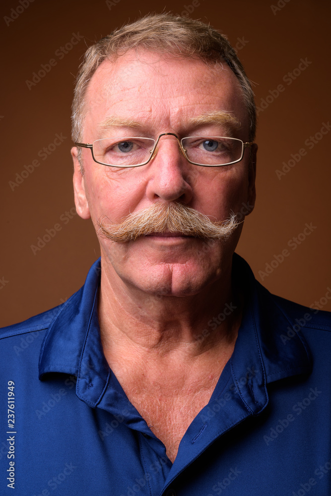 Obraz premium Face of senior man with mustache wearing eyeglasses