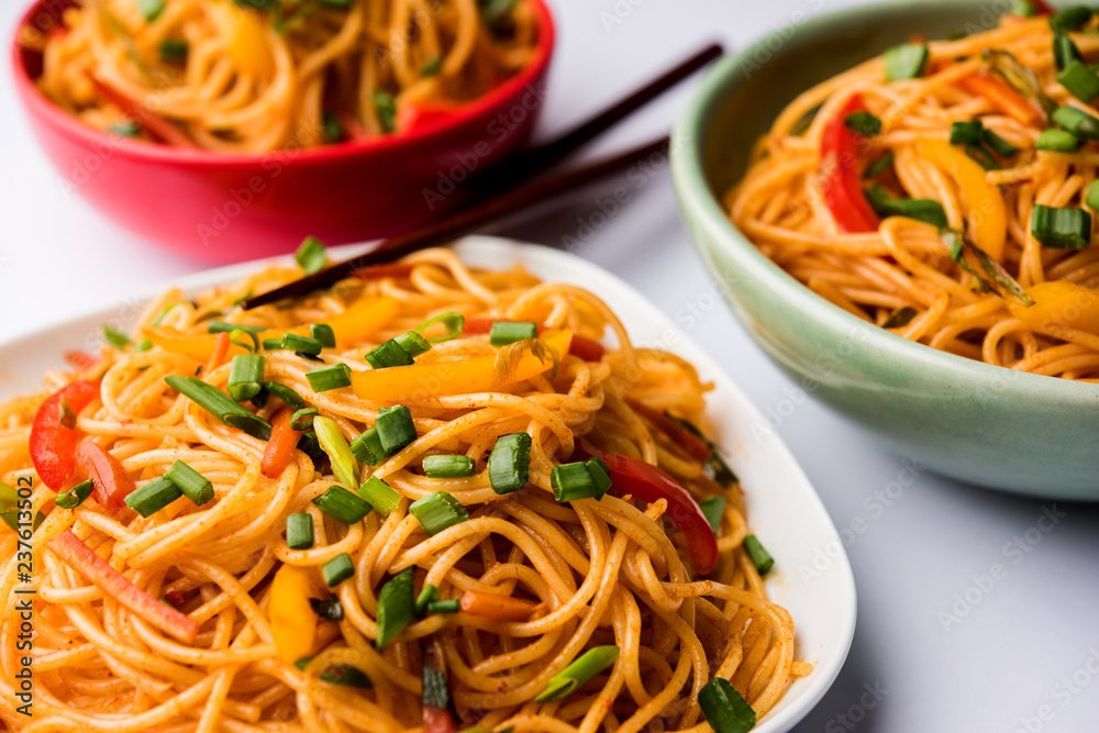 Schezwan Noodles or vegetable Hakka Noodles or chow mein is a popular Indo-Chinese recipes, served in a bowl or plate with wooden chopsticks. selective focus Schezwan Noodles or vegetable Hakka Noodles or chow mein is a popular Indo-Chinese recipes, served in a bowl or plate with wooden chopsticks. selective focus