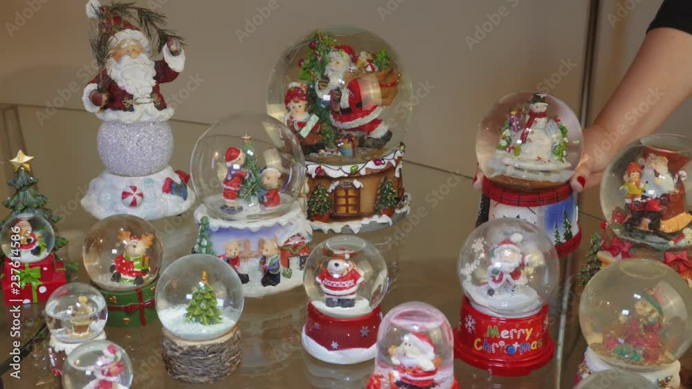 Hand decorating many Christmas snow globe balls on a table.
Female putting festive Christmas dome balls depicting Santa Claus and other seasonal figures. Hand decorating many Christmas snow globe balls on a table.
Female putting festive Christmas dome balls depicting Santa Claus and other seasonal figures.