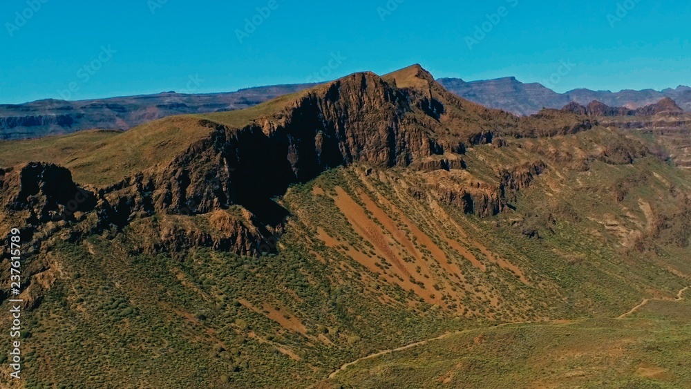 aerial drone image of beautiful stunning landscape view off the Degollada de La Yegua viewpoint with cliff rock peaks and valley with a curvy road on a sunny day