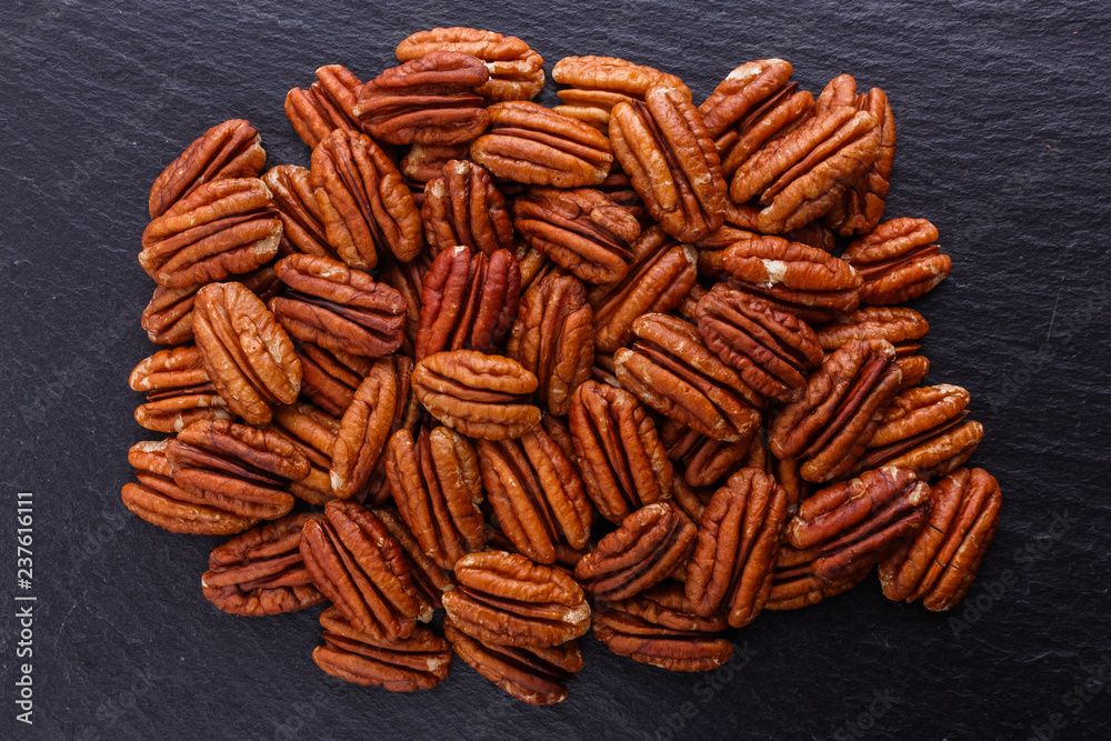 delicious pecan nuts on a dark stone background delicious pecan nuts on a dark stone background