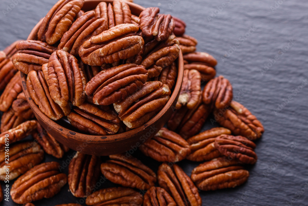 delicious pecan nuts on a dark stone background delicious pecan nuts on a dark stone background