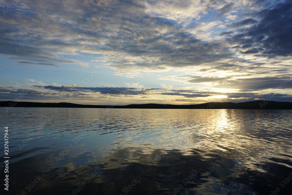 Beautiful sunset over a lake  with clouds and reflection in Finland