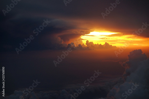 Beautiful big thunder storm over the cloud during sunset from the airplane