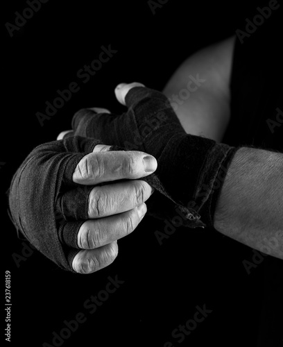 man wraps his hands in black textile bandage