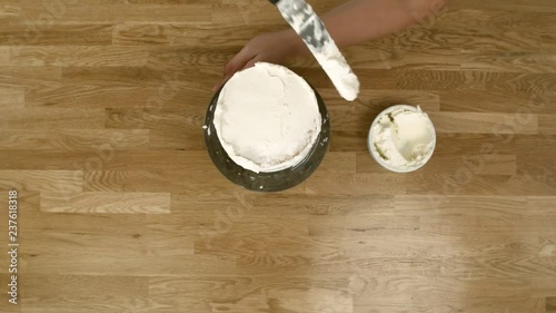 A Woman Rotating A Cake Around to Frost It