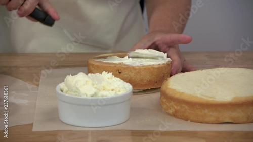 A Woman Frosting a Cake with White Icing