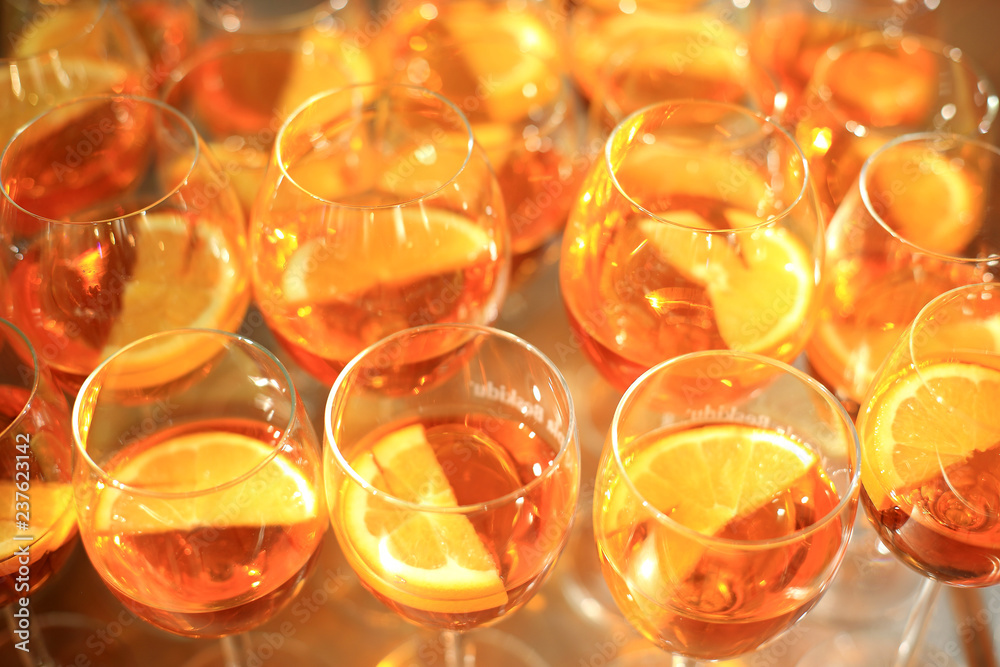 Kieliszki pomarańczowego wina z plastrami pomarańczy, lampki z winem. - obrazy, fototapety, plakaty 