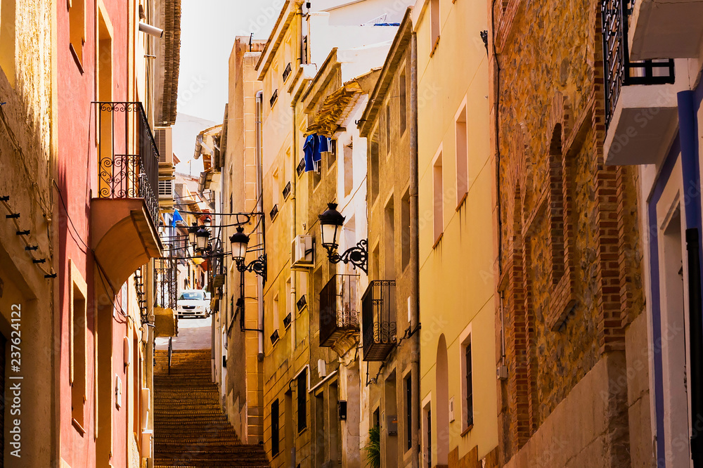 Cozy street of the old European city Relleu. Mediterranean architecture in Spain.