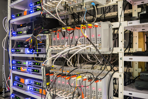 Many audio and video wires are connected to the distribution modules of the TV station.  Rack with telecommunication equipment is in the server room of the data center