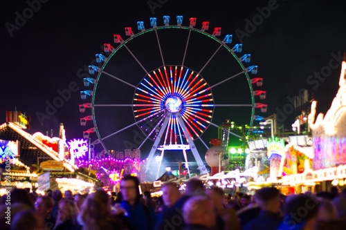 ferris wheel at night with blurry crowd in the foreground