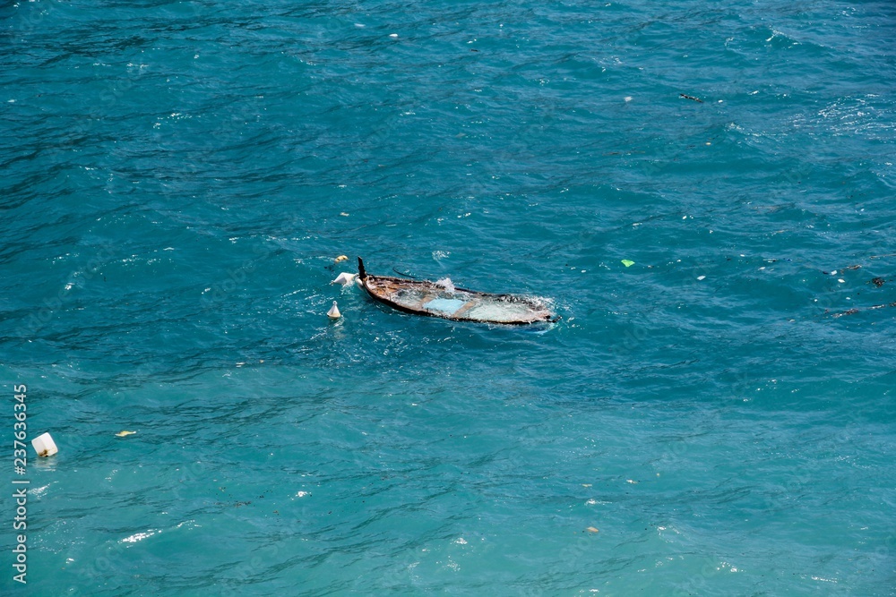 Fototapeta premium Half sunken boat at Cinque Terre in Monterosso al mare, Italy