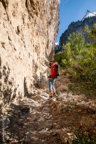 Traveler climbs along narrow mountain gorge