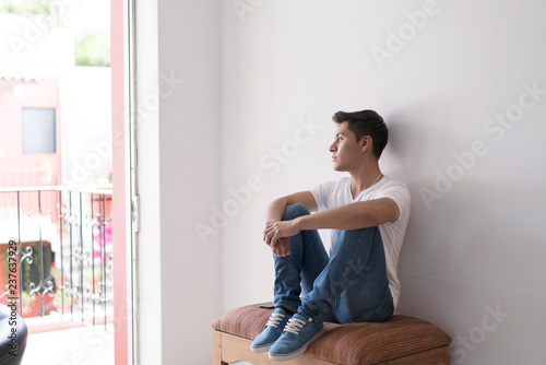 Young man looking outside of a window
