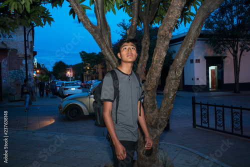 Young man looking up on a street corner