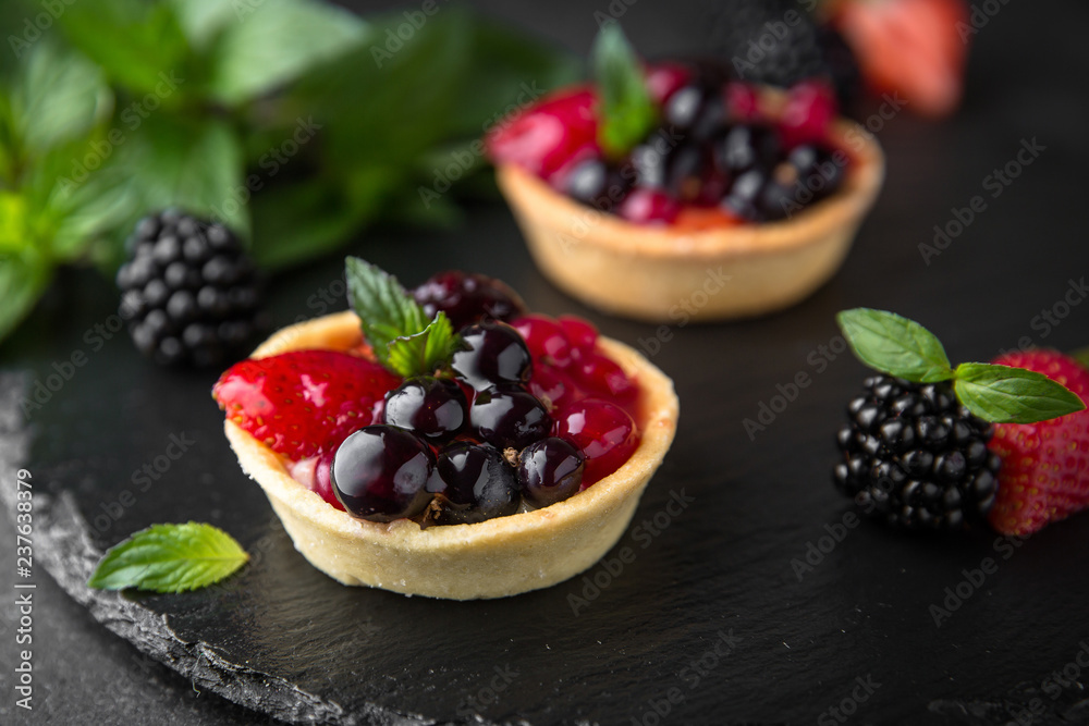 Pastry berry tart. Delicate crispy, crumbly dessert with black and red currants and mint. Assorted Confectionery Range. Pastry berry tart. Delicate crispy, crumbly dessert with black and red currants and mint. Assorted Confectionery Range.