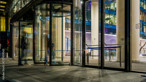  the flow of people passing through the revolving door of the modern office building at the end of the working day