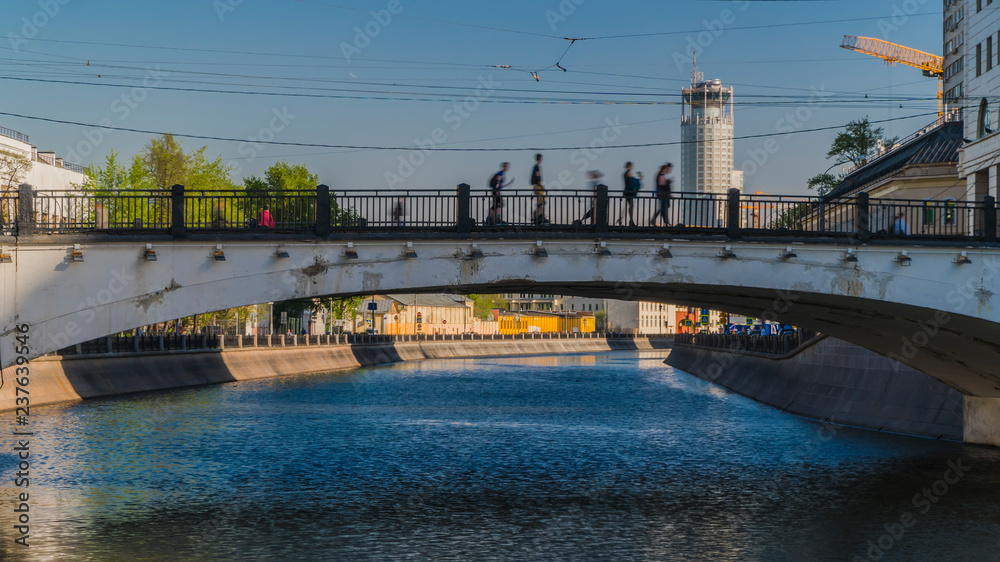 Fototapeta premium people crossing the city's canal at the hump-backed bridge