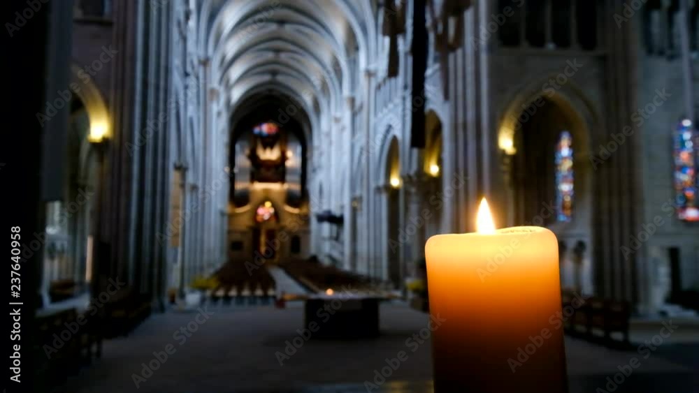 Defocused interior of catholic cathedral, candle at foreground Defocused interior of catholic cathedral, candle at foreground