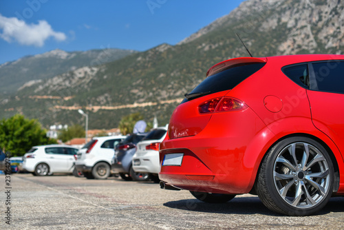 red hatchback car parked in row of mountain parking