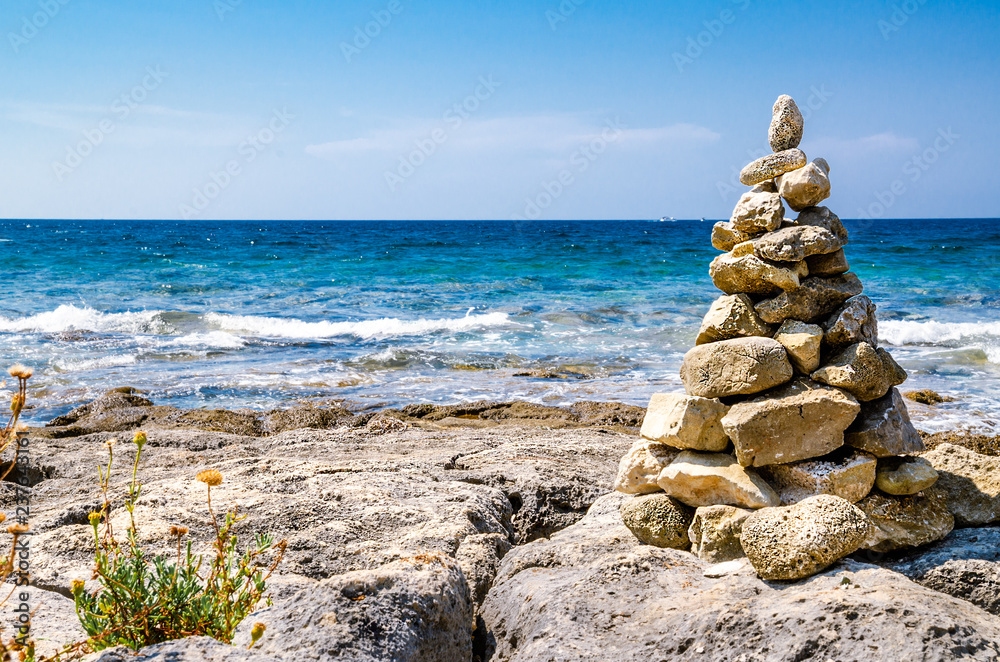 Relaxing and meditative view of the blue sea with pyramid of stones. Relaxing and meditative view of the blue sea with pyramid of stones.